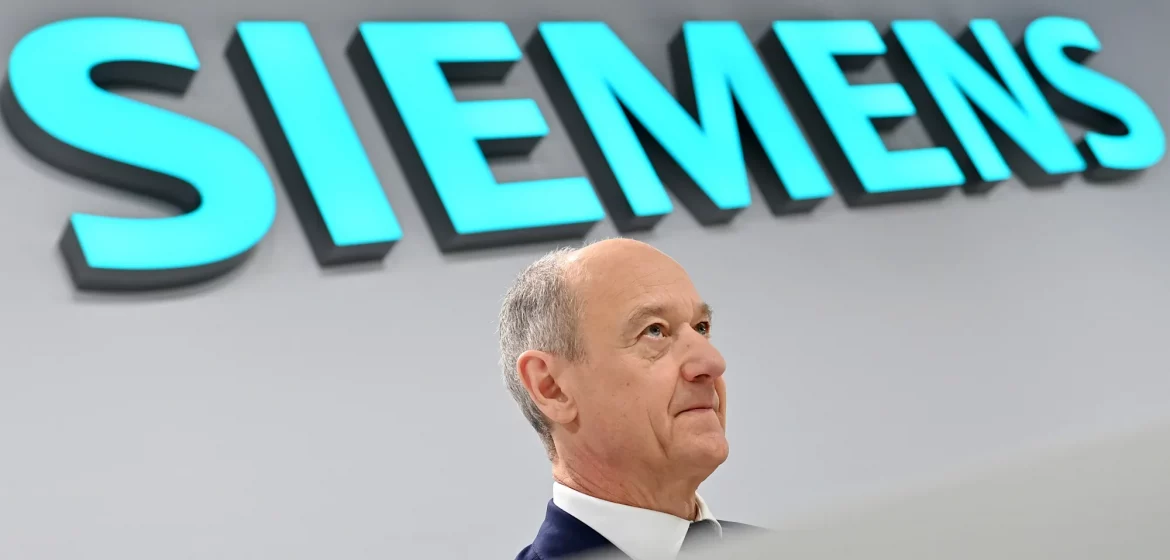 Siemens siedelt einen neuen zentralen Konzernbereich im Ausland an. Roland Busch kritisiert die EU-Regeln für KI und warnt vor umfassenden China-Zöllen.