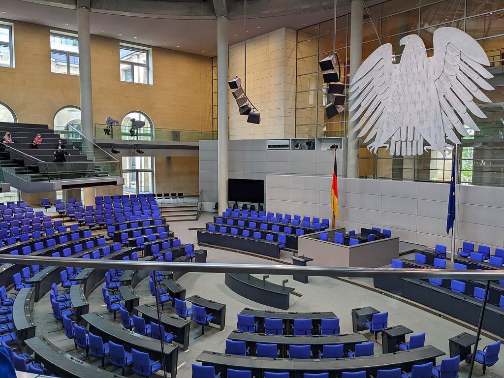 Leerer Plenarsaal des Bundestags im Reichstagsgebäude mit Bundesadler